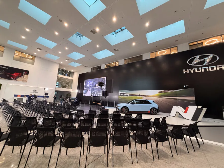 Hyundai-Veranstaltungsraum mit Bühne, Leinwand und Stuhlreihen
